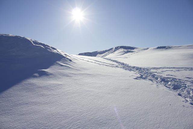 Footprints in snow along a mountain ridge.